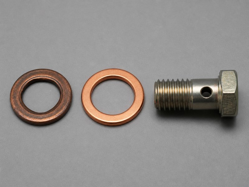old crushed copper banjo bolt washers next to new ones showing work-hardening and flattening