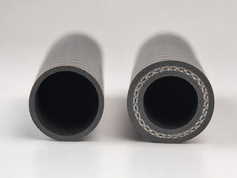 Cross-section of lightweight garden hose walls: a thin vinyl wall beside a thick reinforced multi-layer wall at the same bore