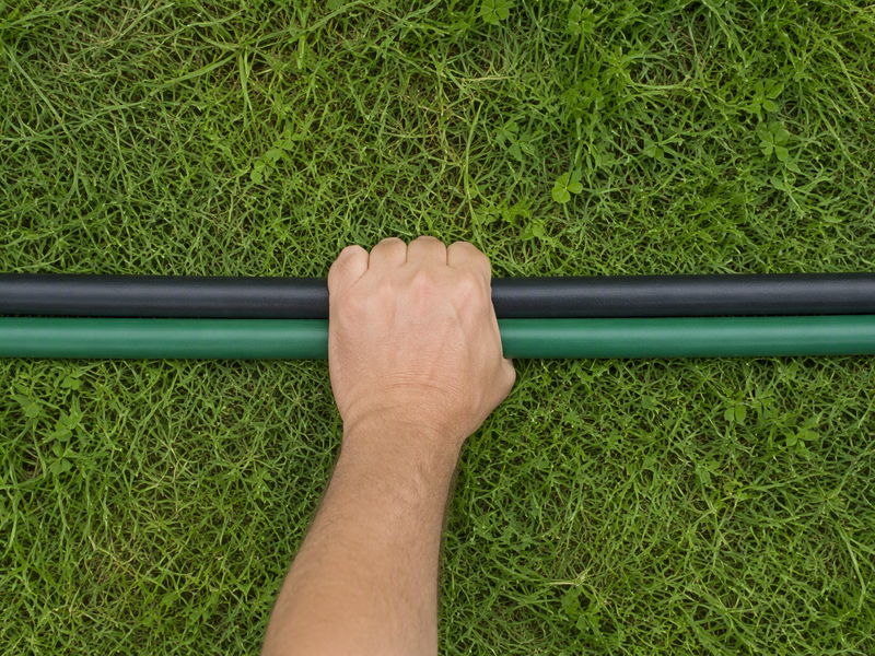 Two garden hoses of the same diameter laid side by side on grass