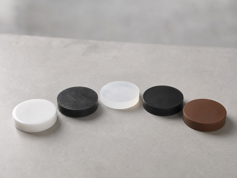 Five liner material samples — white PTFE, black UHMWPE, translucent XLPE, black EPDM and brown FKM — fanned out on a clean bench.
