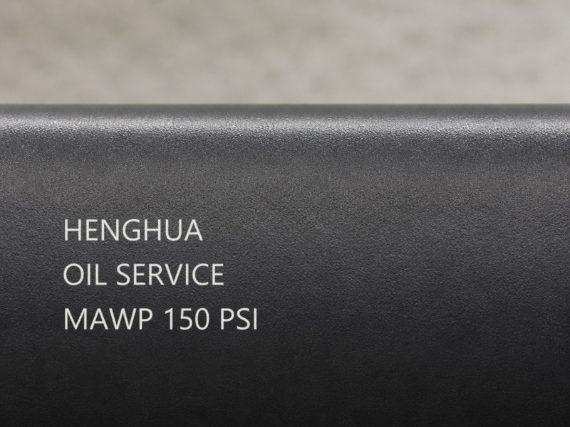 Chemical hose marking label showing service code, MAWP and manufacture date on a hose cover