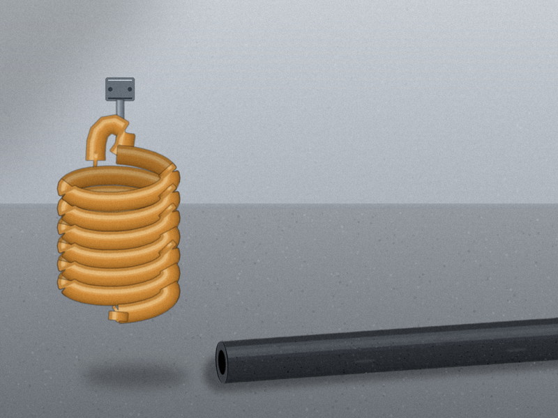A coiled polyurethane air hose next to a straight 3/8 inch rubber air hose on a workshop floor