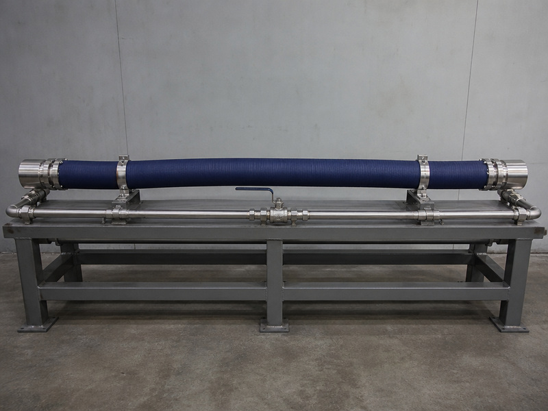 Hydrostatic pressure test bench holding a chemical hose assembly during a factory test